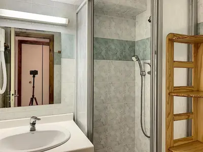 a bathroom with a sink and a shower with a mirror at Joli 2 pièces + studio au centre de Combloux - FR-1-560-74 in Combloux