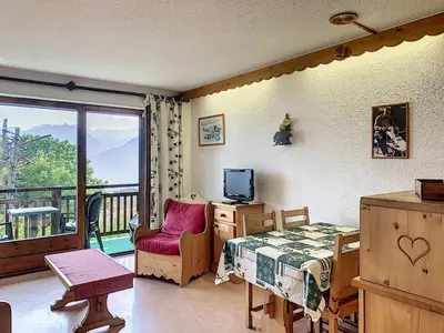 a bedroom with a bed and a television and a balcony at Joli 2 pièces + studio au centre de Combloux - FR-1-560-74 in Combloux