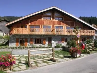 a large wooden house with a fence in front of it at Ferme rénovée 4 ch, 3 sdb, PARKING, WIFI, proche pistes et commerces - FR-1-572-25 in Arâches-la-Frasse