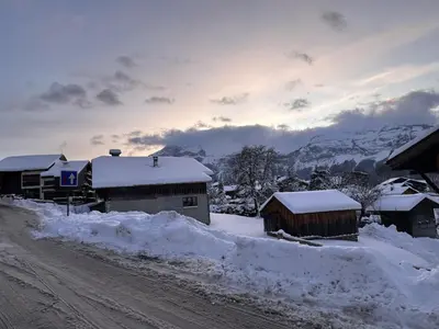 a snow covered village with buildings and a dirt road at Ferme rénovée 12 pers, 450m des pistes, navette gratuite, balcon S-O, parking, WIFI - FR-1-572-23 in Arâches-la-Frasse