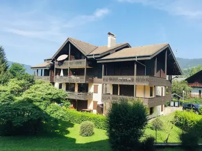 a large house on a hill with a green yard at Appartement confort 4 pers avec balcon et garage, coeur de Samoëns - FR-1-629-101 in Samoëns