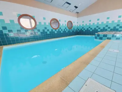 a large swimming pool with two mirrors on the wall at Appartement familial avec piscines à Samoëns - FR-1-624-103 in Samoëns