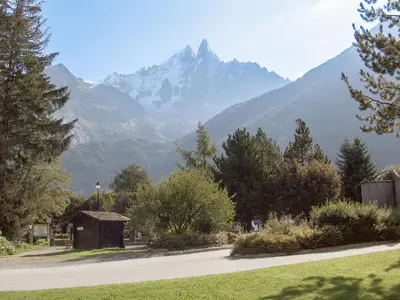 a mountain in the distance with a road and trees at Apartment Alpen Roc by Interhome in Chamonix-Mont-Blanc