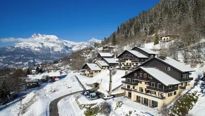 a lodge in the snow with mountains in the background at Studio & piscine intérieure, vue Mont D'Arbois in Saint-Gervais-les-Bains