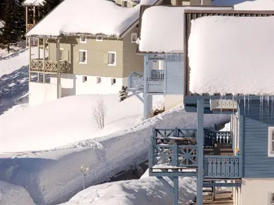 a house covered in snow next to a building at Chalet lumineux avec poêle à bois et WIFI gratuit - 6 à 8 personnes - Garage - FR-1-425-117 in Flaine