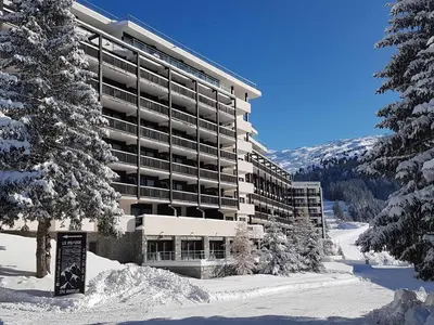 a large building with snow in front of it at Appartement lumineux au pied des pistes avec piscine et spa - FR-1-425-133 in Flaine