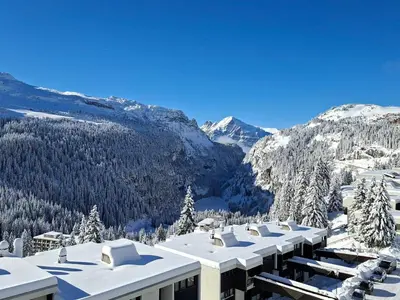 a building with snow on it with mountains in the background at Appartement au pied des pistes avec piscine et parking - FR-1-425-189 in Flaine