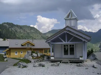 a church with a steeple on top of a building at Chalet lumineux · Sauna privatif · Garage · 12 personnes - FR-1-425-119 in Arâches-la-Frasse