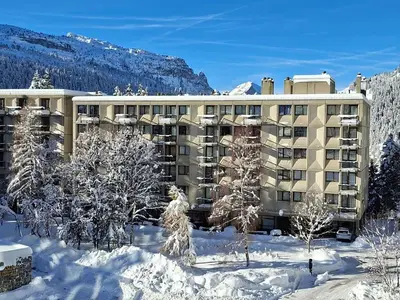 a large building in the snow with trees in front at Appartement rénové 2 pièces pour 6, balcon proche pistes et commerces - FR-1-425-158 in Arâches-la-Frasse