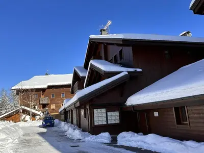 a building covered in snow with a car parked next to it at 3 pièces, 6 pers, animaux admis, parking, vue sur piscine - FR-1-572-5 in Arâches-la-Frasse