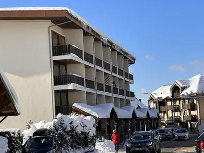 a snow covered building with cars parked in a parking lot at Studio 4 pers, cabine, Les Carroz, proche pistes - FR-1-572-95 in Arâches-la-Frasse