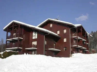 a large brown building with snow on the ground at Charmant 2P avec balcon, 5 couchages, pieds des pistes, proche télécabine et centre village - FR-1-572-171 in Arâches-la-Frasse