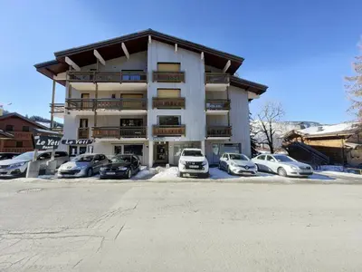 a large building with cars parked in a parking lot at 3 pièces pour 6 personnes face aux pistes et commerces, stationnement inclus - FR-1-572-190 in Arâches-la-Frasse