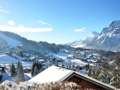 a village covered in snow with mountains in the background at Appartement cosy 6 pers. au pied des pistes, balcon sud-ouest, proche centre, ski-in/ski-out - FR-1-572-155 in Arâches-la-Frasse