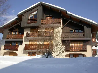 a building with balconies and snow in front of it at Appartement cosy 6 pers. au pied des pistes, balcon sud-ouest, proche centre, ski-in/ski-out - FR-1-572-155 in Arâches-la-Frasse