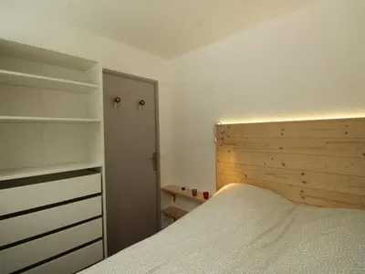 a bedroom with a bed and a wooden headboard at Appartement rénové 3 pièces - 6 pers - Balcon Sud - Résidence Sirius à Flaine Forêt - FR-1-687-5 in Arâches-la-Frasse