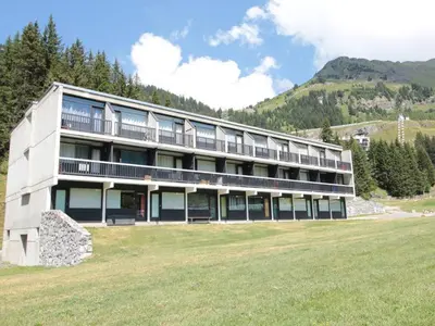 a large building with a grass field in front of it at Studio cosy 4 pers, skis aux pieds, terrasse sud, Flaine Front de Neige - FR-1-687-73 in Arâches-la-Frasse