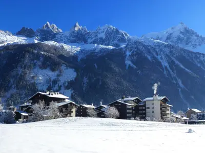 a resort in the snow with mountains in the background at Studio au pied des pistes à Chamonix avec parking privé, proche centre - FR-1-343-162 in Chamonix-Mont-Blanc