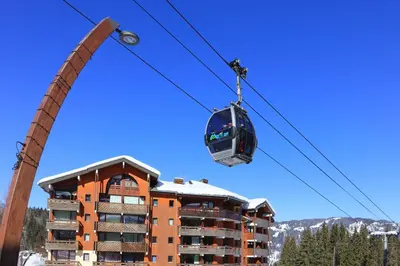a gondola is being lifted on a ski lift in front of a building at Les Sitelles - 18 - Belle vue Appart 6 pers in Morillon