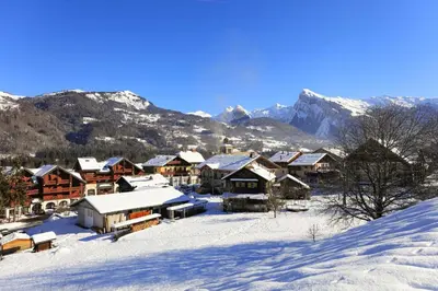 a village in the snow with mountains in the background at Le Grand Neige - 36 - Appart Montagne 6 pers in Morillon
