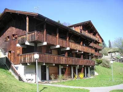 a wooden house with a balcony with flowers on it at Apartment Les G'rets-12 by Interhome in Saint-Gervais-les-Bains