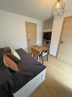 a bedroom with a large bed and a table at Charmant studio Saint Gervais 74 in Saint-Gervais-les-Bains