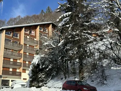 a red car parked in front of a snow covered building at Charmant Studio-Cabine 4 pers, Centre-Village, Balcon Ouest, à 600m des Pistes - FR-1-572-281 in Arâches-la-Frasse