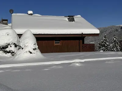 a house covered in snow with trees in the background at Appartement 3 pièces cabine, 6 pers, face au spa et au ski bus, proche pistes et commodités - FR-1-572-45 in Arâches-la-Frasse