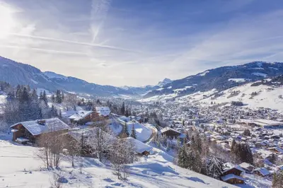 a village covered in snow with mountains in the background at Chalet Albert 1 er Megeve village in Megève